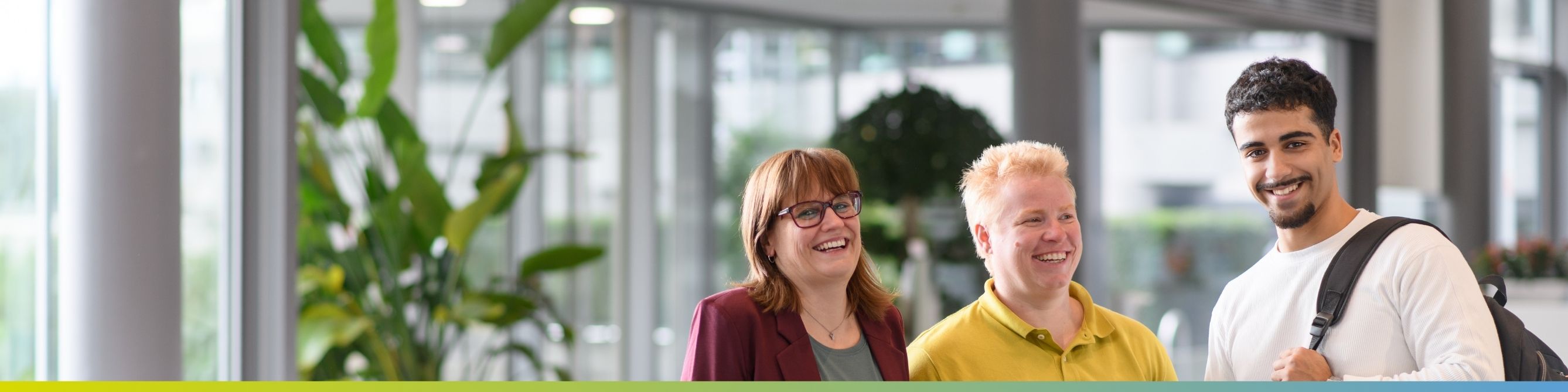 Drei Kolleg:innen machen sich auf den Weg zu einem Messestand auf einer Karrieremesse