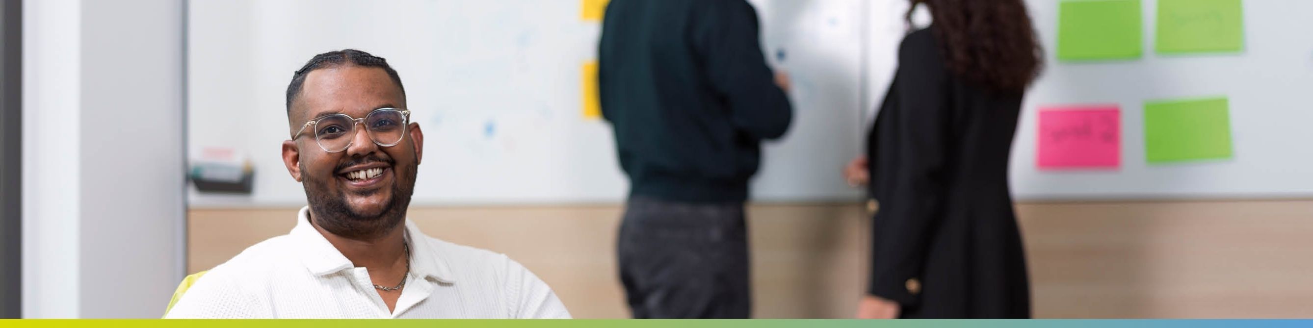 Ein Azubi arbeitet mit anderen Auszubildenden im Büro