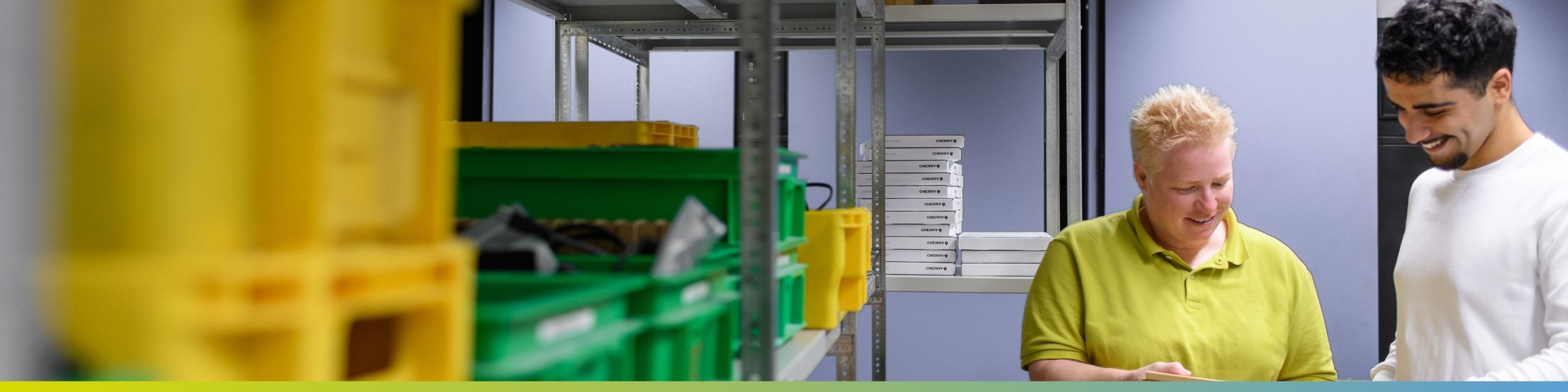 Eine Kollegin und ein Kollege arbeiten zusammen im Lagerraum für Hardware